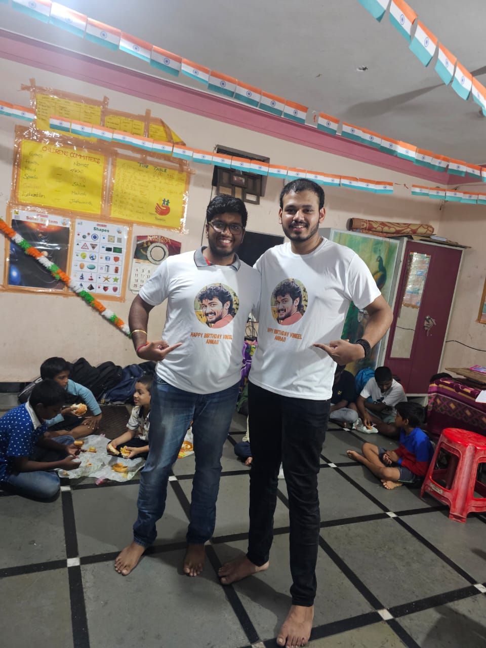 Aditya Raj and Saketh wearing custom birthday t-shirts with Vineel Anna's photo at orphanage celebration